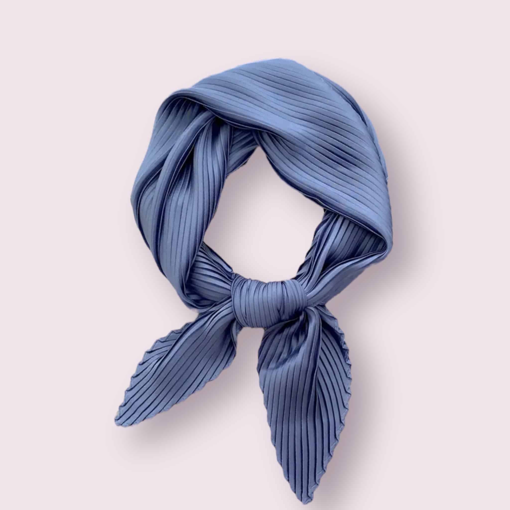 Élégant foulard en satin de couleur bleu, délicatement plissé.